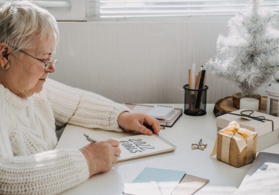 Elderly Women Writing on a Notepad